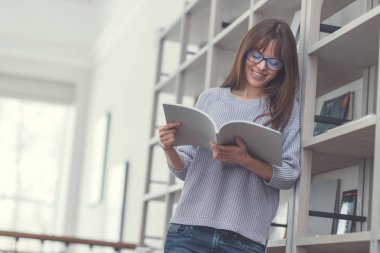 Gülümseyen çekici kadın bir kitap okuma