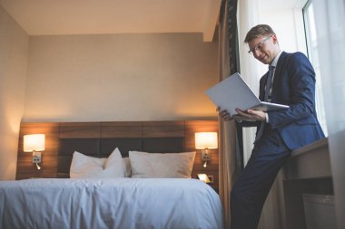 Oda içinde laptop ile gülümseyen iş adamı