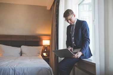 Dizüstü bilgisayar ile takım elbiseli genç işadamı