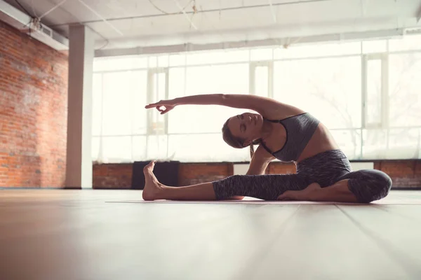 Chica atractiva en una clase de yoga —  Fotos de Stock