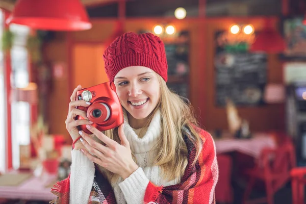 Lachende aantrekkelijke vrouw met een rode polaroid — Stockfoto