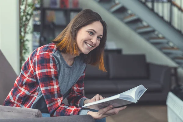 Usměvavá mladá dívka v knihovně — Stock fotografie