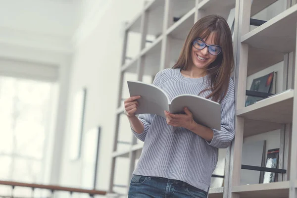 Sorrindo mulher atraente lendo um livro — Fotografia de Stock