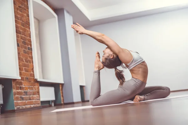 Młoda kobieta praktykująca jogę w studio — Zdjęcie stockowe