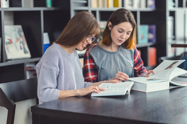 Jonge studenten in de bibliotheek — Stockfoto