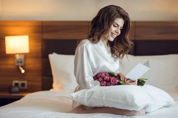 Mujer sonriente con ramo en el hotel —  Fotos de Stock