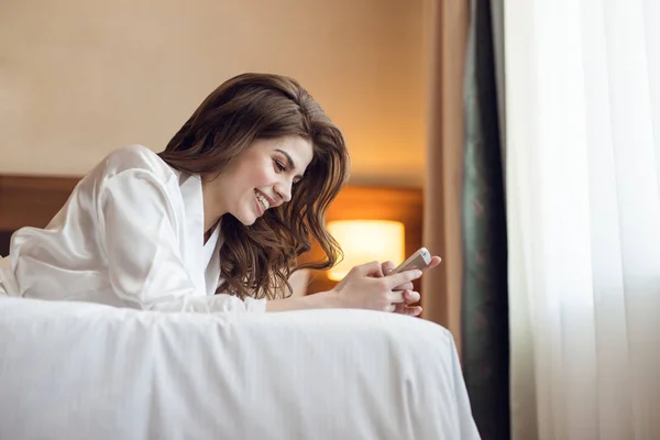 Lachende meisje met telefoon in het hotel — Stockfoto