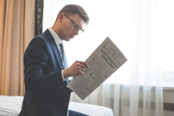 Jeune homme d'affaires en costume lisant un journal — Photo