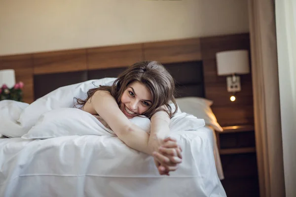 笑容迷人的女人在床上 — 图库照片