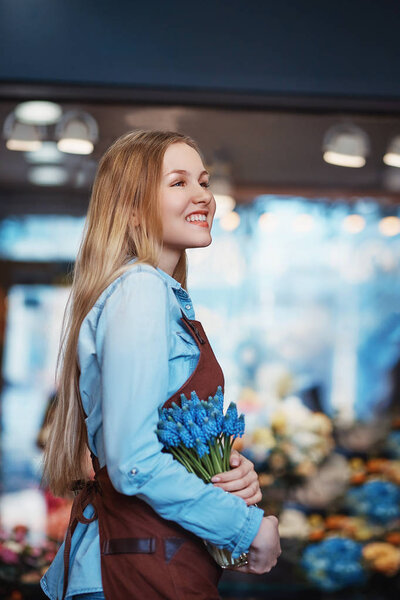 Smiling woman with muscari indoors