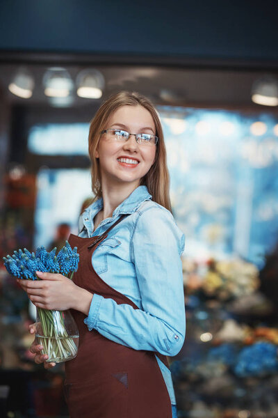 Smiling girl with flowers in a store