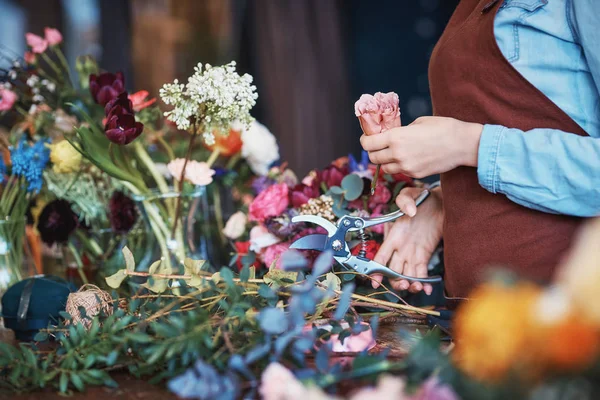 Floristería joven en uniforme con flores —  Fotos de Stock