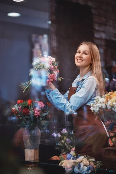 Sorrindo jovem florista em uniforme — Fotografia de Stock