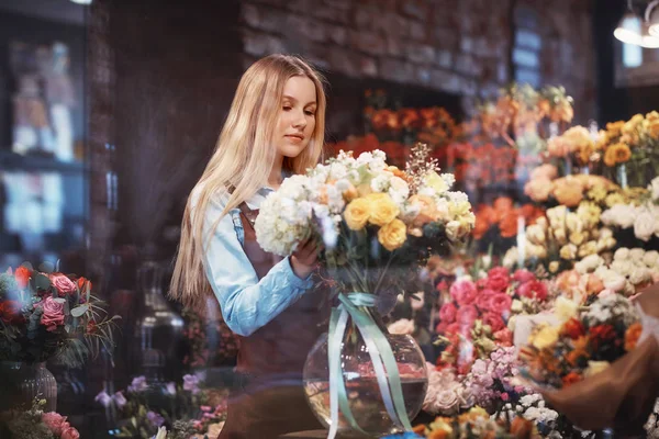 Mujer joven en uniforme con flores — Foto de Stock
