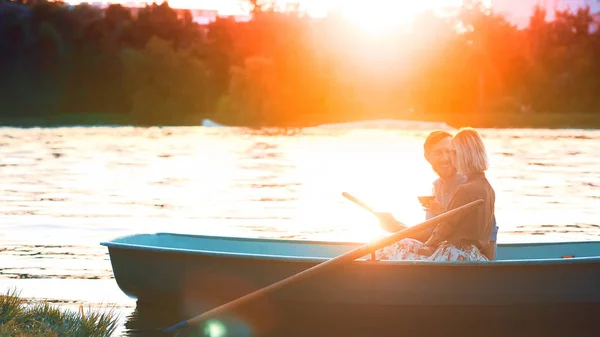 Jovem casal em um barco à luz do sol — Fotografia de Stock