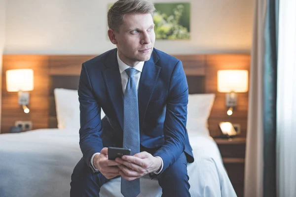 Joven hombre de negocios con teléfono en la habitación — Foto de Stock