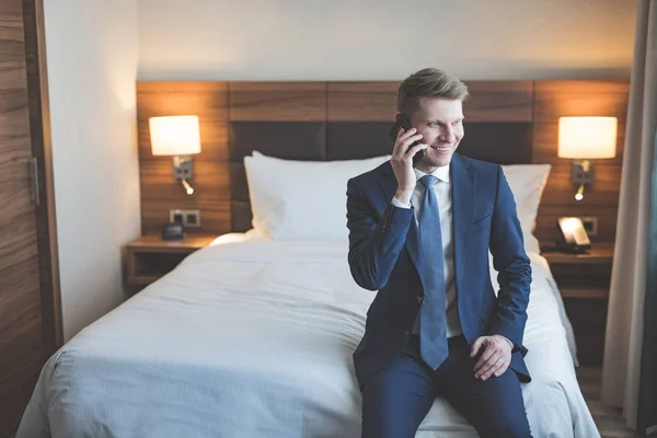 Usmívající se muž mluví o telefonu v hotelu — Stock fotografie