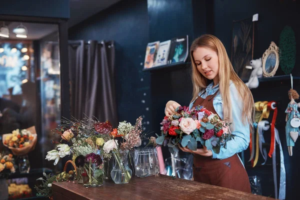 Unga florist med blommor — Stockfoto