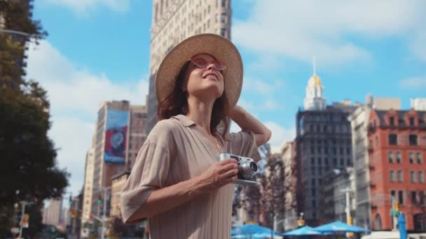 在纽约弗拉蒂隆酒店的背景下 一个带着复古相机的迷人女孩 — 图库视频影像