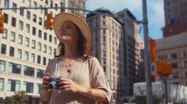 New York 'ta Manhattan' da elinde retro kamerayla gülümseyen kadın.