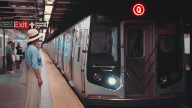 Çekici kız metro istasyonunda treni bekliyor.