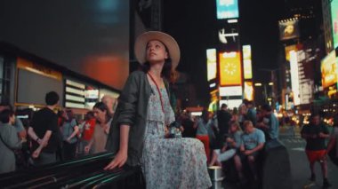 Geceleri Times Meydanı 'nda elinde retro kamerayla genç bir turist.