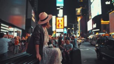 Gece vakti Times Meydanı, Nyc 'te elinde retro kamera olan genç bir kadın.