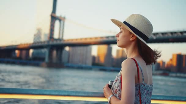 Chica joven con una cámara retro en el puente de Manhattan — Vídeo de stock