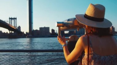 Gün batımında New York 'ta dürbünlü genç kız
