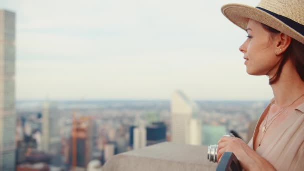 ニューヨークの超高層ビルの屋根にレトロなカメラを持つ魅力的な女の子 — ストック動画