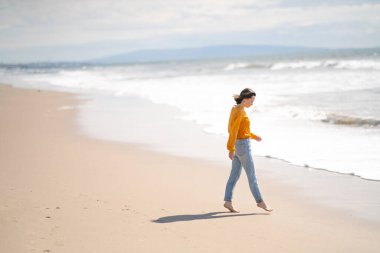 Sahilde çıplak ayaklı genç bir kız