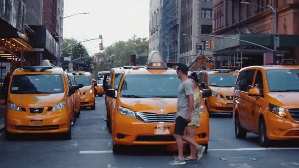 Mladí lidé přecházejí silnici před taxíkem v New Yorku — Stock video