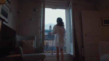 Young girl running to open the balcony in the morning