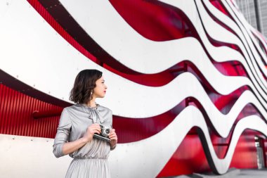 Dışarıda elinde retro kamerayla genç bir fotoğrafçı.