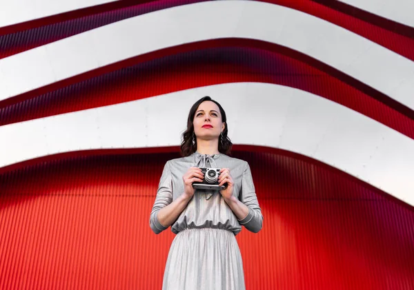 Junger Fotograf an der roten Wand — Stockfoto
