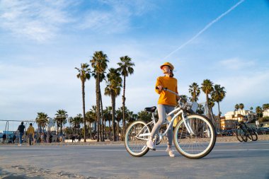 Los Angeles 'ta bisikleti olan genç bir kadın.