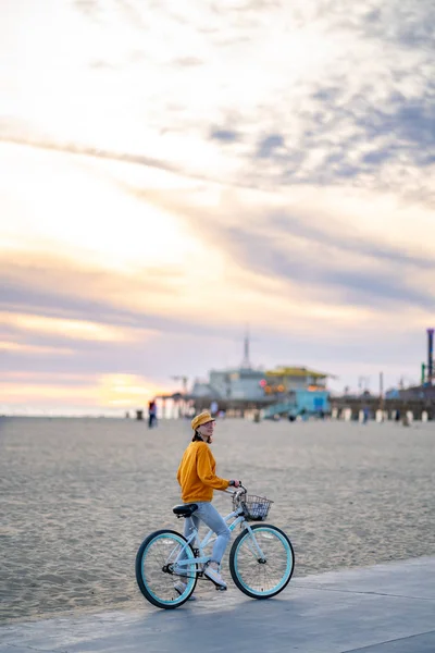 Улыбающаяся девушка с велосипедом на пляже, Лос-Анджелес — стоковое фото