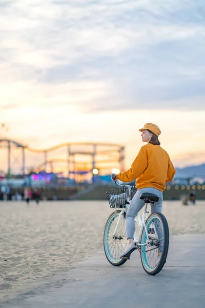 Young tourist with bike at sunset — ストック写真