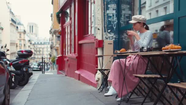 迷人的女孩在巴黎的一家街头咖啡馆里吃早餐 — 图库视频影像