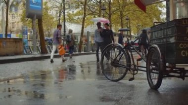Paris 'te insanlar yağmur altında sokakta.