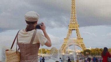 Paris 'teki Eyfel Kulesi' nde şapka takan genç fotoğrafçı.