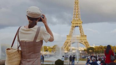 Genç fotoğrafçı Paris 'teki Eyfel Kulesi' nin fotoğrafını çekiyor.