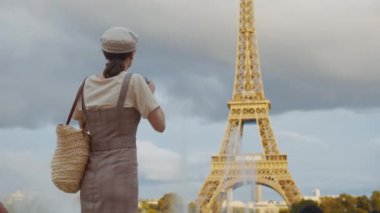Paris 'teki Eyfel Kulesi' nin fotoğrafını çeken çekici bir kadın.