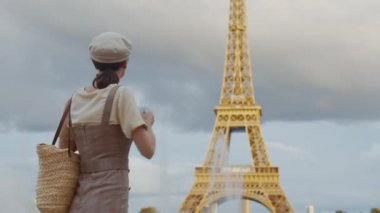 Fransa 'daki Eyfel Kulesi' nde elinde retro kamera olan genç bir turist.