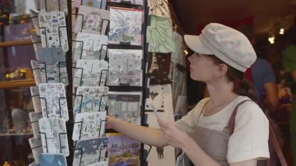 Όμορφο Κορίτσι Διαλέγει Καρτ Ποστάλ Ένα Κατάστημα Στο Παρίσι — Αρχείο Βίντεο