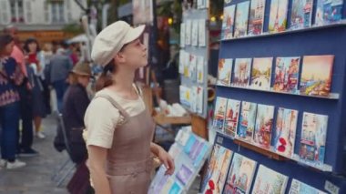Paris 'teki Montmartre' da resimlere bakan genç bir kadın.