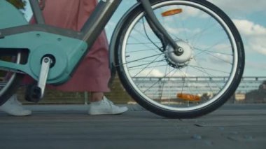 Köprüde bisikletli genç bir kadın. Yakın plan.
