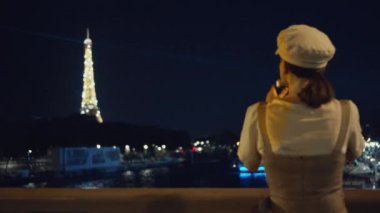 Genç fotoğrafçı gece Paris 'te Eyfel Kulesi' nin fotoğrafını çekiyor.