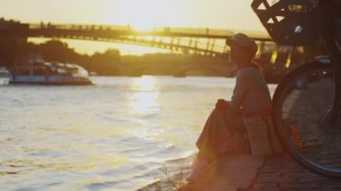 Gün batımında şehirde bisikletli çekici bir kız.