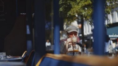 Paris 'te bir kafede kahvaltı yapan genç bir turist.